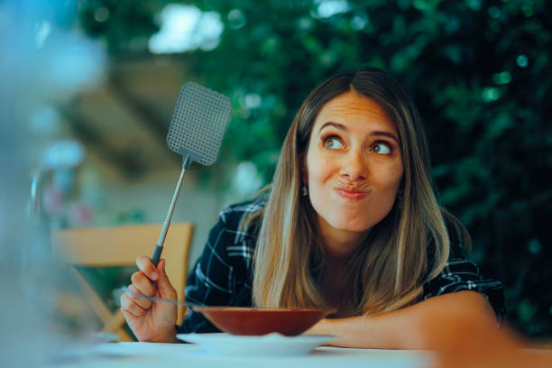 femme à table avec tapette à moustique
